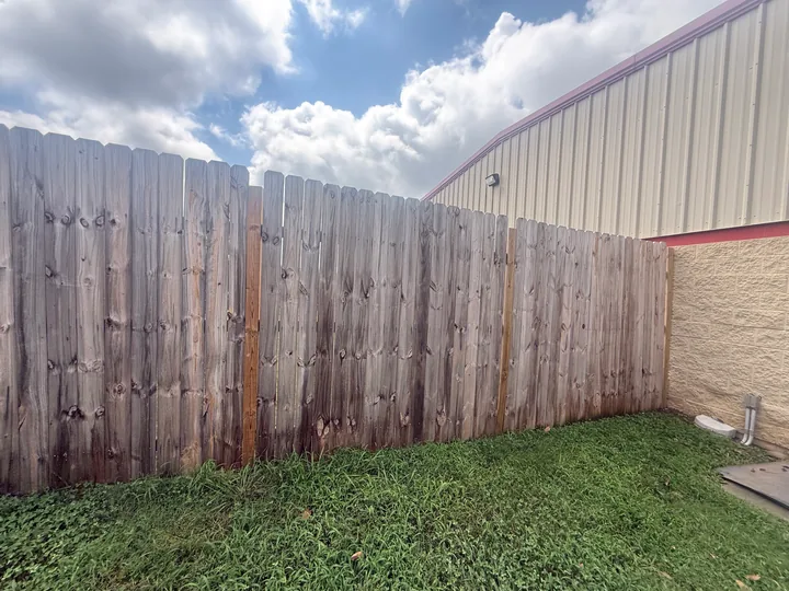Timber privacy fence panels and horizontal rails beside a building