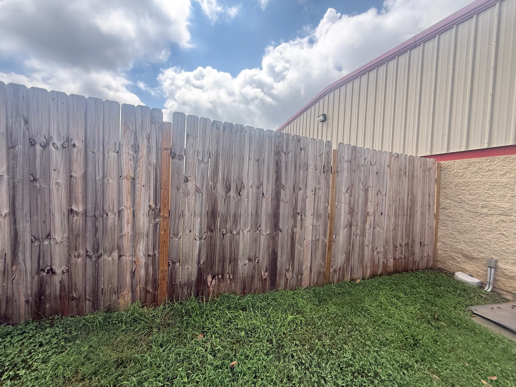 Timber privacy fence panels and horizontal rails beside a building