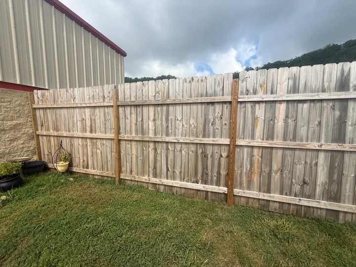 Timber privacy fence panels and horizontal rails beside a building