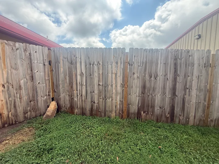 Timber privacy fence panels and horizontal rails beside a building