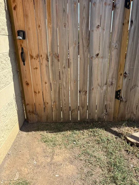 Timber privacy fence panels and horizontal rails beside a building