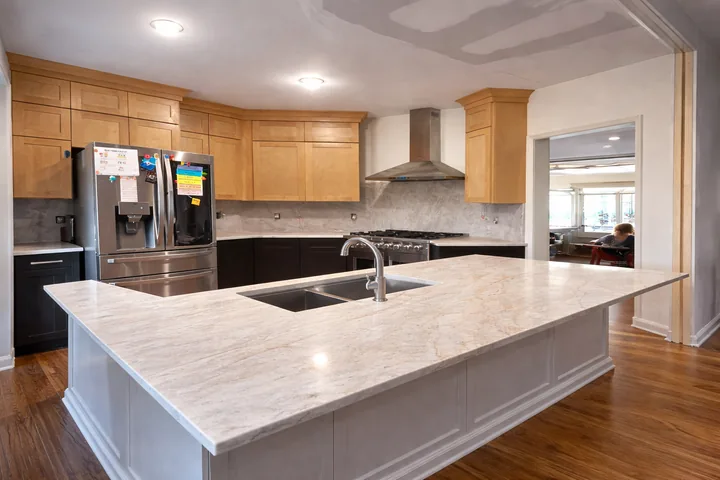 Wood kitchen cabinetry with a broad light island countertop