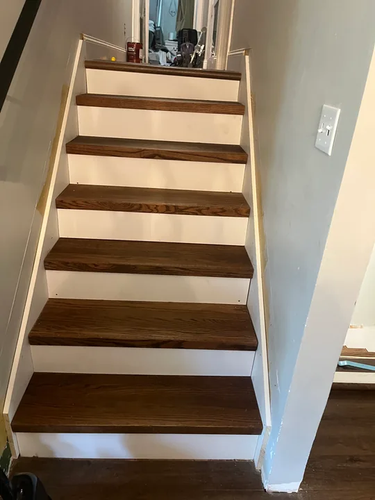 Wood stair treads with white painted risers and wall trim