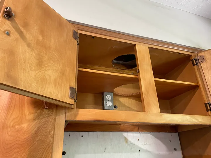 Open wood storage compartments and shelving beside a window