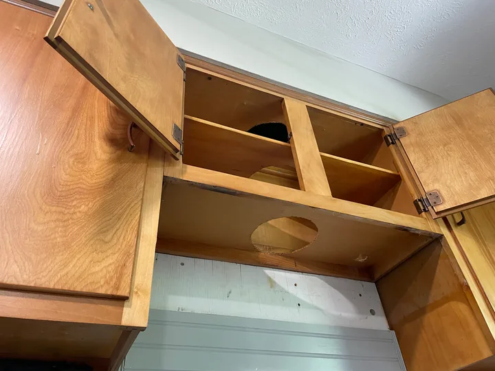 Open wood storage compartments and shelving beside a window